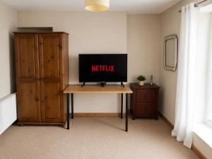 a television sitting on a table in a room with a dresser at 54 - Room 3 - City views in Swansea