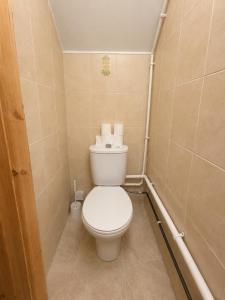 a small bathroom with a toilet with towels on it at 54 - Room 3 - City views in Swansea +4 photos