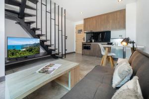 a living room with a couch and a table and a kitchen at Relax, Swim & Stay Active in this Duplex - UTL B131 in Rawai Beach
