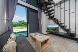a living room with a couch and a tv and a staircase at Relax, Swim & Stay Active in this Duplex - UTL B131 in Rawai Beach
