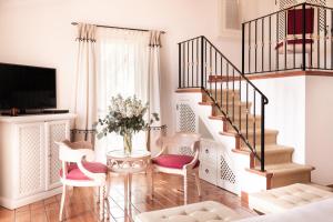 a living room with a staircase and a table and chairs at Il Pellicano in Porto Ercole