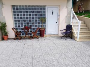 a patio with a white door and a table and chairs at Maresia BIKE ROOMS in São Félix da Marinha