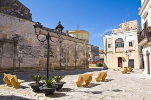 a courtyard with yellow chairs and a street light at La Dimora del Colle in Mottola