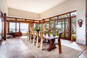 a dining room with a wooden table and chairs at Cloud 9 Luxury Eco Villa in Sedgefield