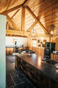 a kitchen with a large island in a room with wooden ceilings at Domaine Sur Les Sarts in Ohey