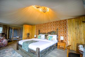 a bedroom with a large bed in a room at Malaika Ndutu Luxury Camp in Sinoni
