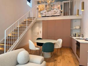 a kitchen with a table and chairs and a staircase at Duplex charmant dans le centre - La suite Incas in Le Puy-en-Velay