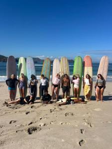 a group of people holding their surfboards on the beach at Ocean Fresh Surfhouse in Pulau Sarang +4 photos