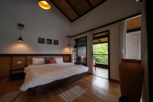 a bedroom with a large bed and a sliding glass door at Red Panda Jungle Camp - A Unit of Davinchi Homes Pvt Ltd in Gyalzing