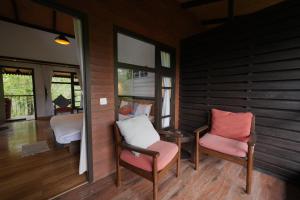 a room with two chairs and a table and windows at Red Panda Jungle Camp - A Unit of Davinchi Homes Pvt Ltd in Gyalzing