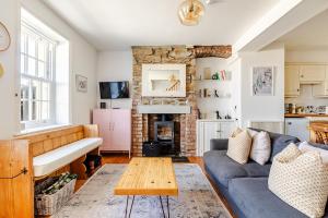 a living room with a blue couch and a fireplace at 2a Coastguard Cottages in Gorran Haven