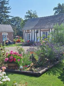 a garden with flowers in front of a house at Gîte Rosie in Saint-Blimont