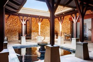 a large room with a pool and a brick wall at Cloud 9 Luxury Eco Villa in Sedgefield