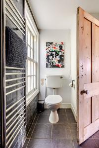 a bathroom with a toilet and a window at 2a Coastguard Cottages in Gorran Haven +35 photos