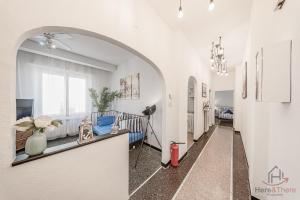 a hallway with an archway and a living room with a couch at Gramsci House - Sea 3 min - Central - Family in Vado Ligure