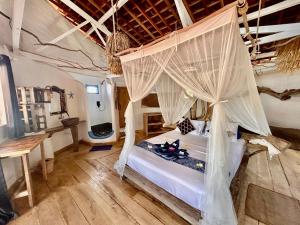 a bedroom with a bed with mosquito nets at SHAYA cottage in Sekotong +152 photos