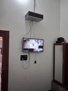 a flat screen tv hanging on a white wall at Hotel Kunj Palace in Etah