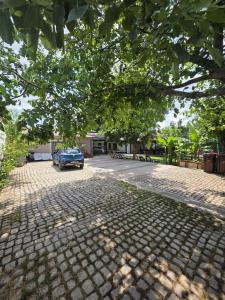 a blue car parked on a cobblestone street at Casa inflorita camere in Eforie Nord