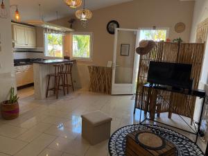 a living room with a kitchen with a counter at Bungalow Les Coraux in La Saline les Bains