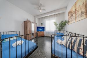 a bedroom with two beds and a ceiling fan at Gramsci House - Sea 3 min - Central - Family in Vado Ligure
