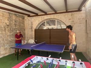 two men standing next to a ping pong table at Masseria Carperi in Cisternino