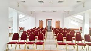 a row of chairs in a room with red chairs at Hotel Europa in Ploieşti