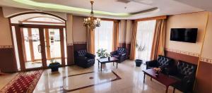 a living room with couches and a tv on the wall at Hotel Europa in Ploieşti