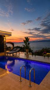 a swimming pool with a view of the ocean at sunset at Vatër by the lake in Shirokë