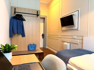 a room with a bed and a desk with a laptop at UNO Smart Hamburg Central 056 in Hamburg