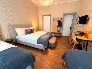 a bedroom with two beds and a table and a desk at UNO Smart Hamburg Central 056 in Hamburg