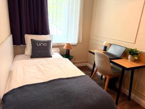 a bedroom with a bed and a desk with a laptop at UNO Smart Hamburg Central 056 in Hamburg +8 photos