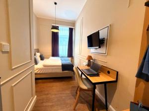 a room with a desk with a laptop and a bed at UNO Smart Hamburg Central 056 in Hamburg