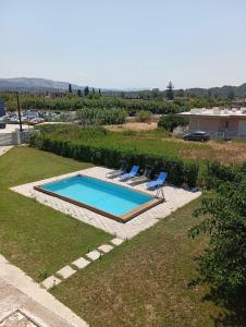 a swimming pool with two lounge chairs next to it at Luna's Summer House in Kremasti