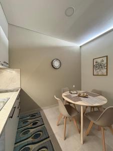 a kitchen with a table and chairs and a clock on the wall at Paloma Apartment in Drama