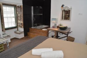 a bathroom with a tub and a table and a sink at Lovin Book Guesthouse in Óbidos