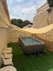 a hot tub on the side of a building with chairs at Beachfront Villa in Moraira