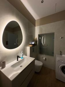 a bathroom with a sink and a toilet and a mirror at Paloma Apartment in Drama
