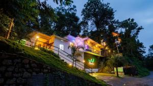 a house on the side of a hill at night at Wild Stories Resort, Munnar in Anachal