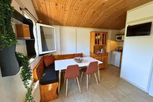 a small kitchen with a table and chairs in a caravan at Camping la Source in Thérondels