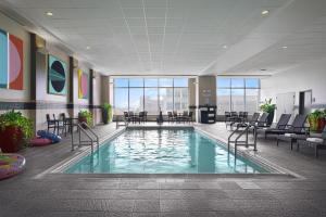 a pool in a hotel lobby with chairs and tables at DoubleTree by Hilton Hotel Cedar Rapids Convention Complex in Cedar Rapids