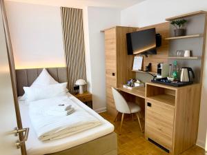 a hotel room with a bed and a desk with a computer at Colleen Apartments Wesertal in Porta Westfalica