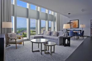 a living room with a couch and tables and windows at DoubleTree by Hilton Hotel Cedar Rapids Convention Complex in Cedar Rapids