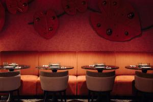 a restaurant with two tables and red hearts on the wall at NYX Hotel Amsterdam Rembrandt Square in Amsterdam