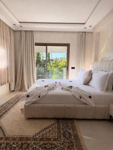 a large white bedroom with a large bed with a window at Riad Villa Elizabeth in Nouaseur