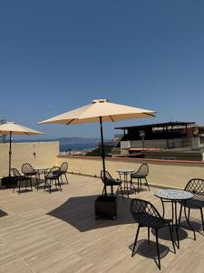 a group of tables and chairs with umbrellas on a patio at Maison ì room, suite & apartment in Reggio di Calabria