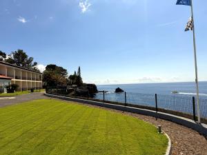 a grassy field next to a building and the ocean at Albatroz Beach & Yacht Club in Santa Cruz +56 photos