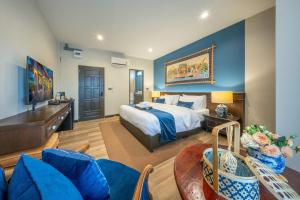 a bedroom with a king sized bed and a living room at Apirom Hometel in Sathani Lak Si