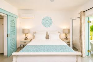 a white bedroom with a bed and two lamps at Le Mandala Moris Boutique Hotel in Grand-Baie +59 photos