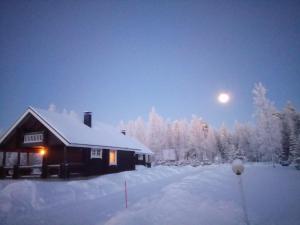 Domek na śniegu z księżycem na niebie w obiekcie Vuokatti Cottages w mieście Vuokatti