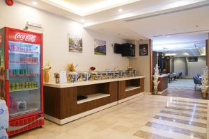 a restaurant with a cocacola refrigerator and a counter at فندق فربيون المجاردة - Ferbion Hotel Almajardah in Al Majaridah
